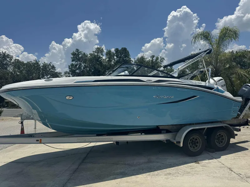 The Image of 2026 Hurricane SunDeck 2050 OB boat on calm lake with canopy and sleek design. - 0