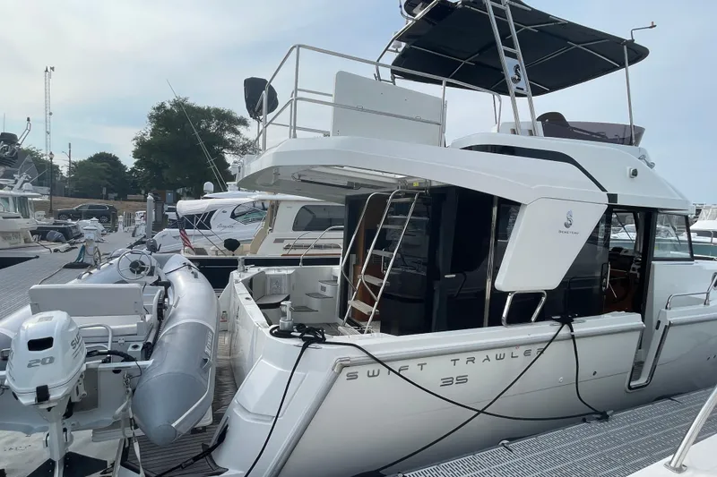 Slide: The Image of 2018 Beneteau Swift Trawler 35 docked, featuring sleek design and modern amenities. - 10