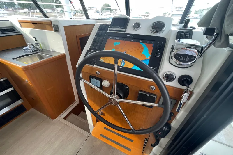 Slide: The Image of 2018 Beneteau Swift Trawler 35 helm with navigation display and steering wheel. - 19
