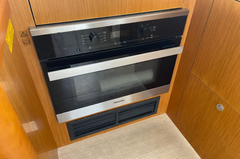 Slide: The Image of Miele oven in 2018 Beneteau Swift Trawler 35 kitchen, wood cabinetry. - 22