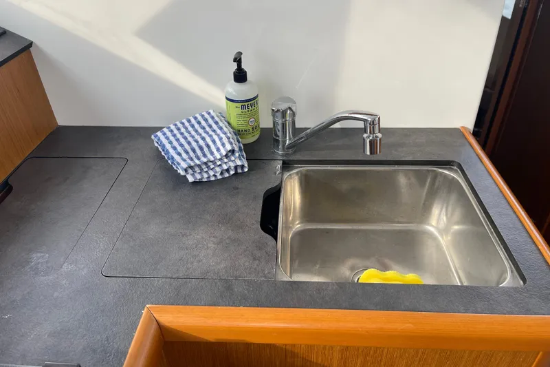 Slide: The Image of Kitchen sink area on 2018 Beneteau Swift Trawler 35 with hand soap and towel. - 24