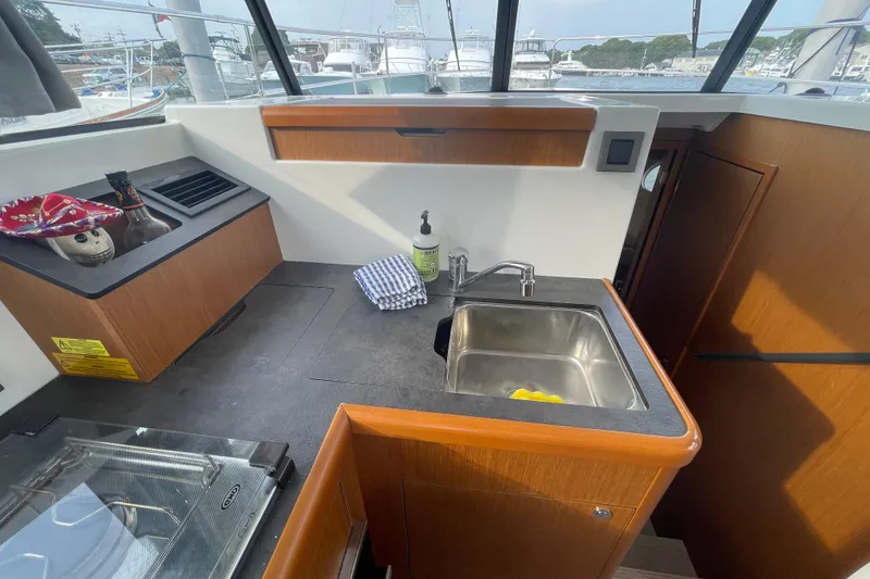 Slide: The Image of 2018 Beneteau Swift Trawler 35 kitchen with sink, countertop, and window view. - 25