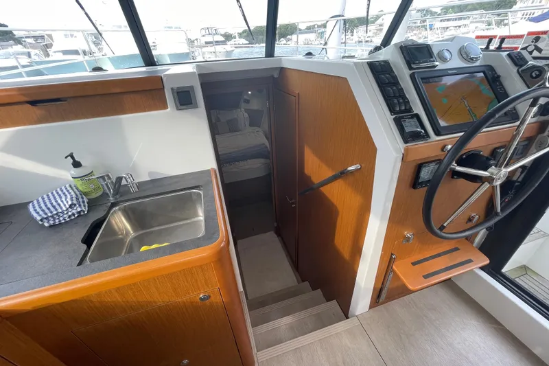 Slide: The Image of 2018 Beneteau Swift Trawler 35 interior with helm, sink, and navigation equipment. - 26