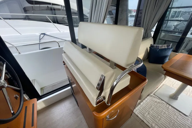 Slide: The Image of Interior of 2018 Beneteau Swift Trawler 35, featuring helm seat and dining area. - 33