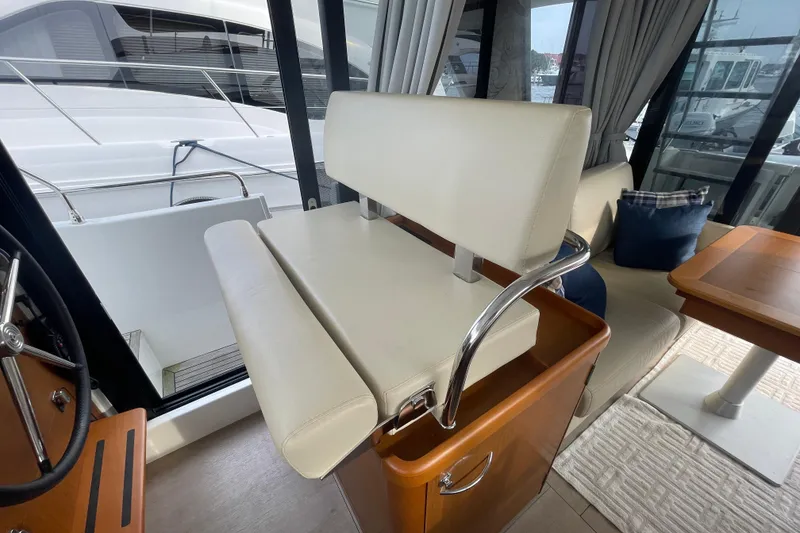 Slide: The Image of Interior of 2018 Beneteau Swift Trawler 35, featuring helm seat and dining area. - 34