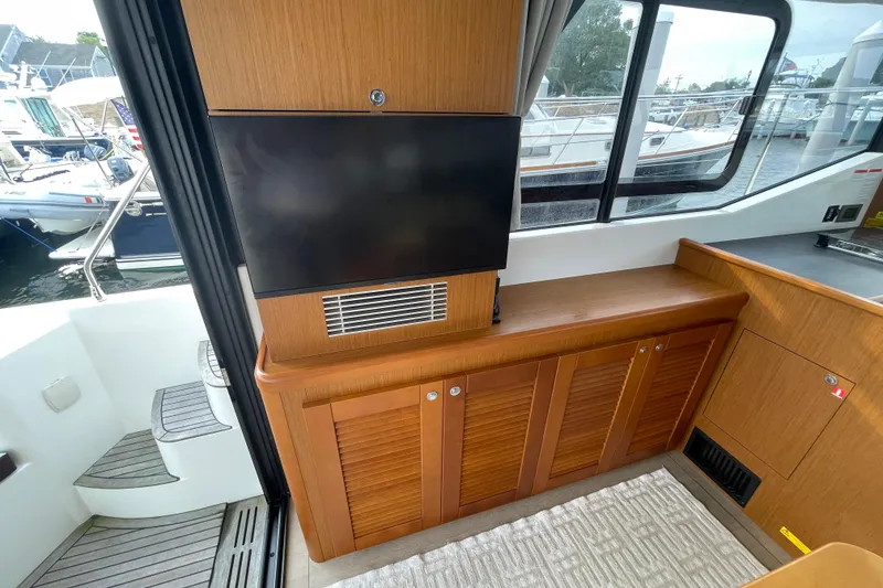 Slide: The Image of 2018 Beneteau Swift Trawler 35 interior with TV and wooden cabinetry. - 37