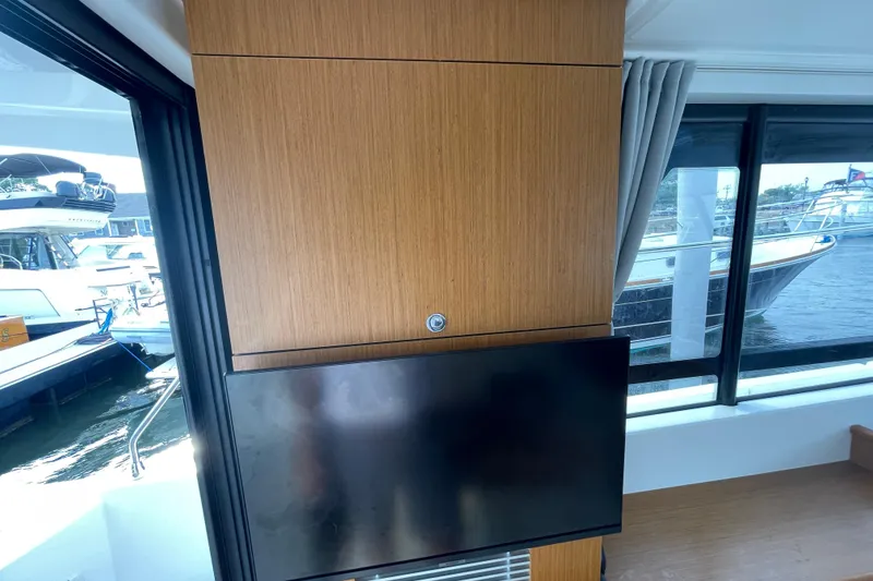 Slide: The Image of Interior of 2018 Beneteau Swift Trawler 35 with mounted TV and marina view. - 38