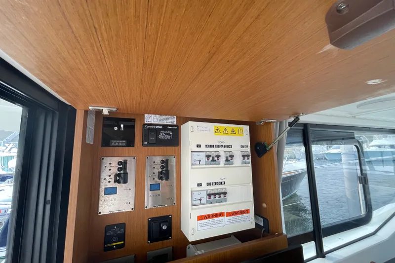 Slide: The Image of Control panel inside 2018 Beneteau Swift Trawler 35, featuring electrical switches and warning labels. - 39