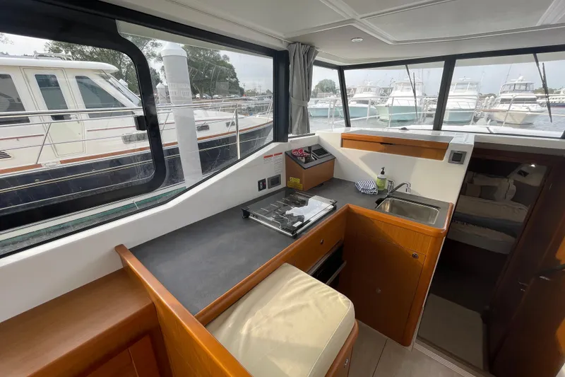 Slide: The Image of Interior of 2018 Beneteau Swift Trawler 35 with kitchenette and marina view. - 47