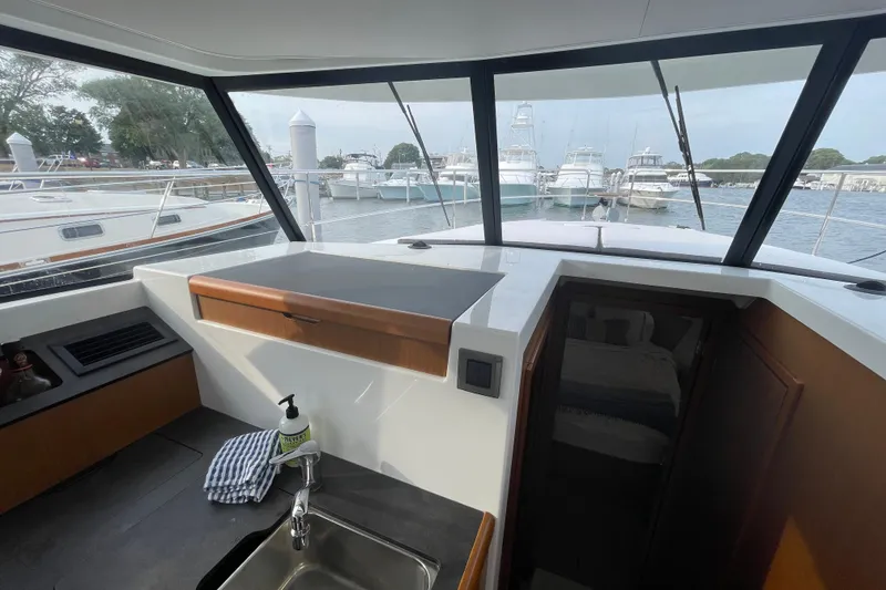 Slide: The Image of Interior view of 2018 Beneteau Swift Trawler 35, showcasing kitchen and marina through windows. - 49