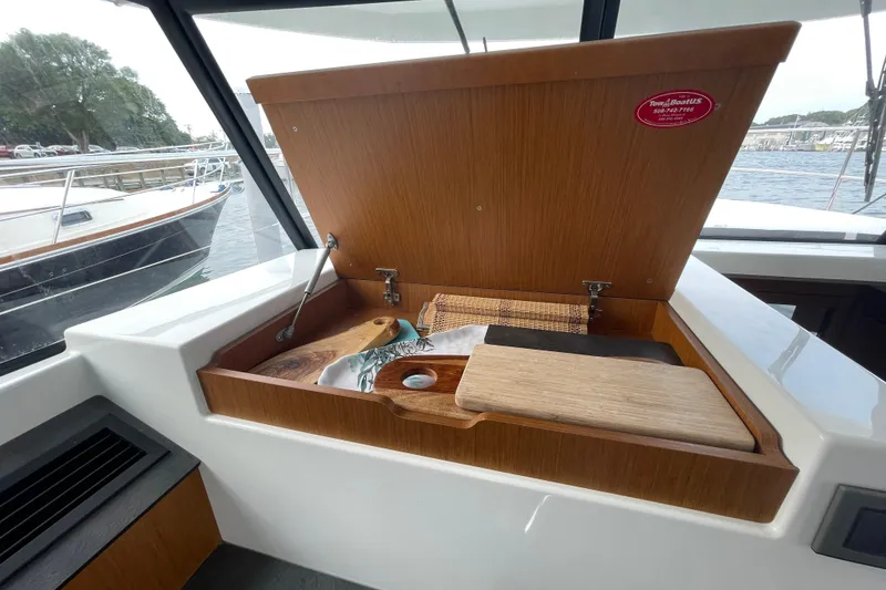 Slide: The Image of 2018 Beneteau Swift Trawler 35 interior with open wooden storage compartment. - 50