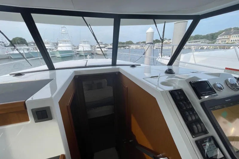 Slide: The Image of 2018 Beneteau Swift Trawler 35 helm with marina view through large windows. - 51