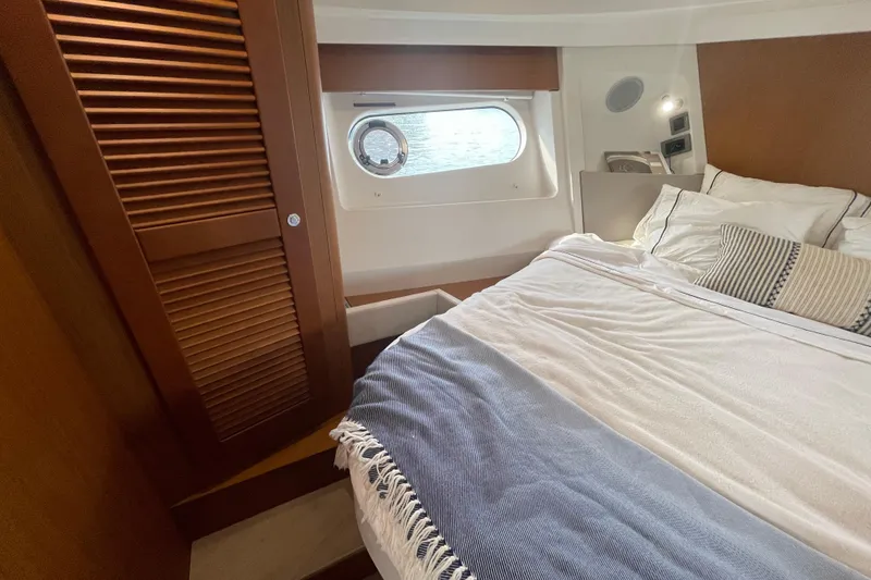 Slide: The Image of Cozy bedroom interior of 2018 Beneteau Swift Trawler 35 with window and wooden accents. - 57