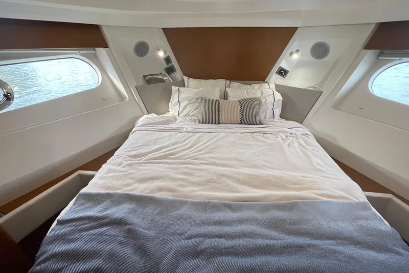 Slide: The Image of Cozy bedroom in 2018 Beneteau Swift Trawler 35 with elegant bedding and porthole views. - 58