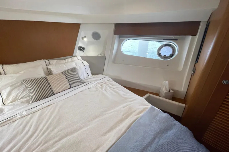 Slide: The Image of 2018 Beneteau Swift Trawler 35 cabin interior with cozy bed and porthole window. - 59