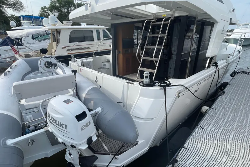 Slide: The Image of 2018 Beneteau Swift Trawler 35 docked with inflatable boat and Suzuki outboard motor. - 6