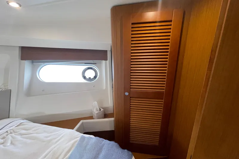 Slide: The Image of Interior cabin of 2018 Beneteau Swift Trawler 35 with wooden closet and porthole window. - 60
