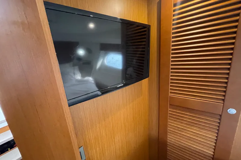 Slide: The Image of 2018 Beneteau Swift Trawler 35 interior with mounted TV and wooden paneling. - 64