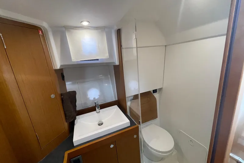 Slide: The Image of 2018 Beneteau Swift Trawler 35 bathroom with sink, toilet, and wooden cabinetry. - 67