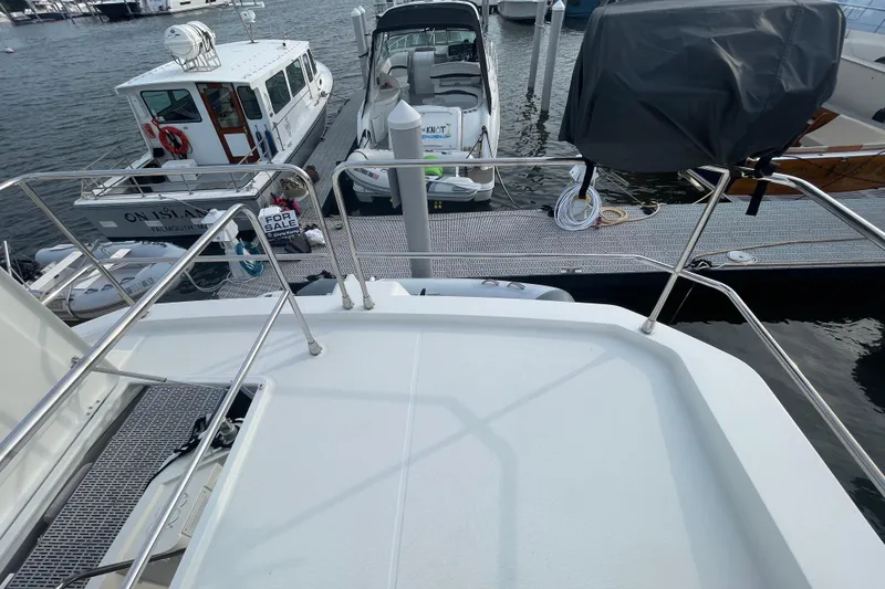 Slide: The Image of 2018 Beneteau Swift Trawler 35 docked, with boats and "For Sale" sign visible. - 76