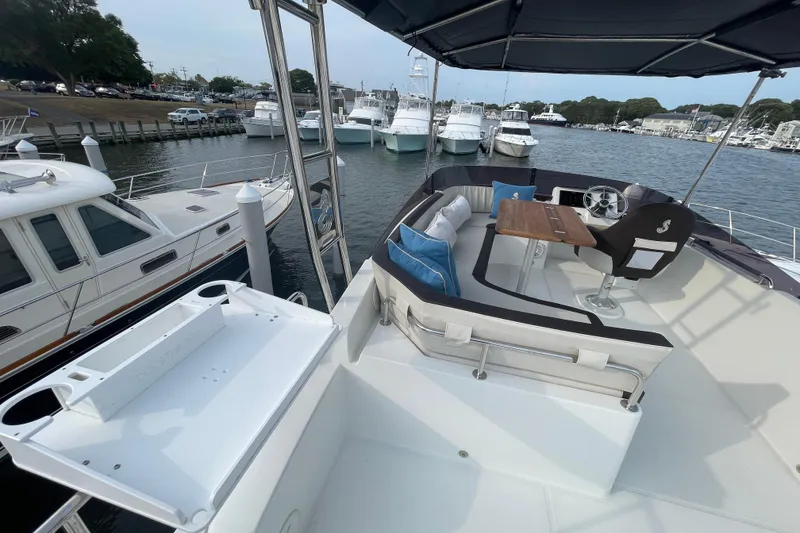Slide: The Image of 2018 Beneteau Swift Trawler 35, docked with seating area and helm, in a marina setting. - 79