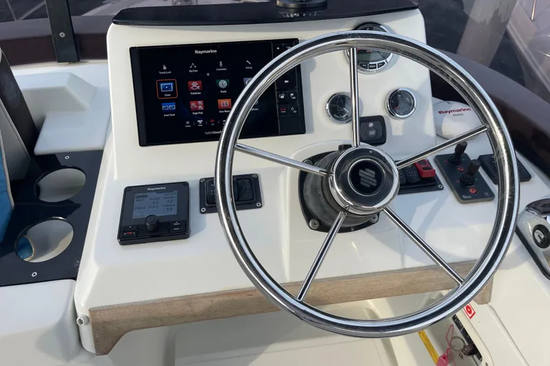Slide: The Image of 2018 Beneteau Swift Trawler 35 helm with Raymarine navigation system and steering wheel. - 86