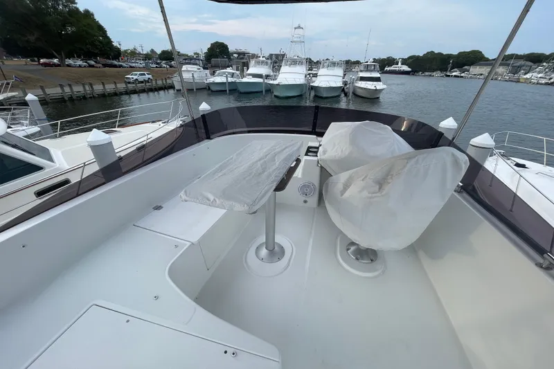 Slide: The Image of Flybridge of 2018 Beneteau Swift Trawler 35, featuring covered seating and table, docked at marina. - 90