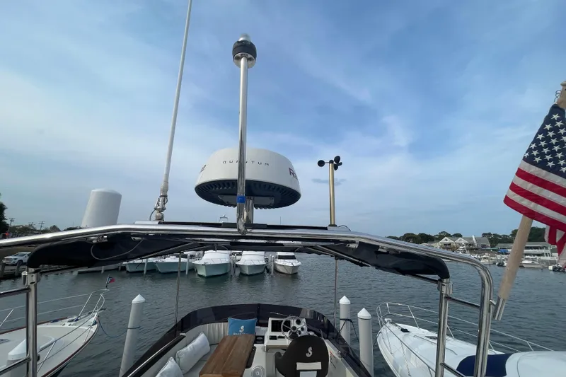 Slide: The Image of 2018 Beneteau Swift Trawler 35 at marina, featuring radar and American flag. - 94