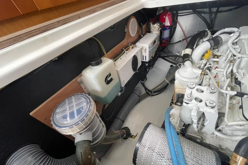 Slide: The Image of Engine room of 2018 Beneteau Swift Trawler 35, showcasing mechanical components and fire extinguisher. - 96