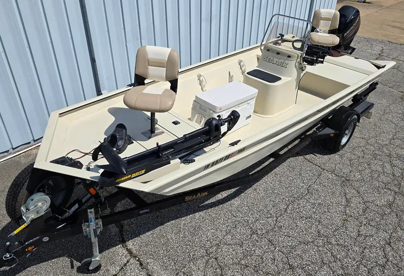 Slide: The Image of 2015 SeaArk RX18 Center Console boat on trailer, featuring beige seating and console. - 1