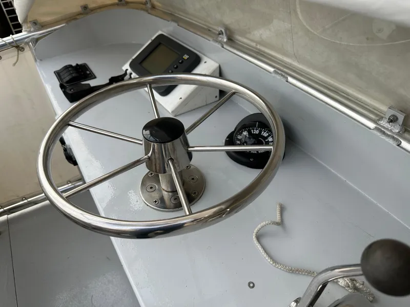 Slide: The Image of Steering wheel and compass on 2003 BHM Sport Fish boat dashboard. - 12