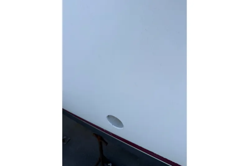 Slide: The Image of Close-up of a 2003 BHM Sport Fish boat hull with a visible hole. - 26