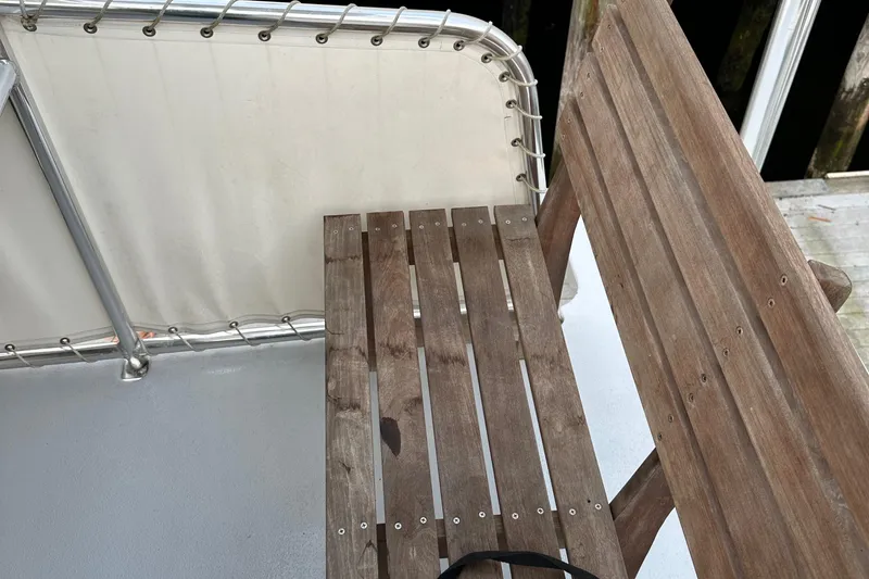 Slide: The Image of Wooden bench on a 2003 BHM Sport Fish boat deck, with metal railing. - 23