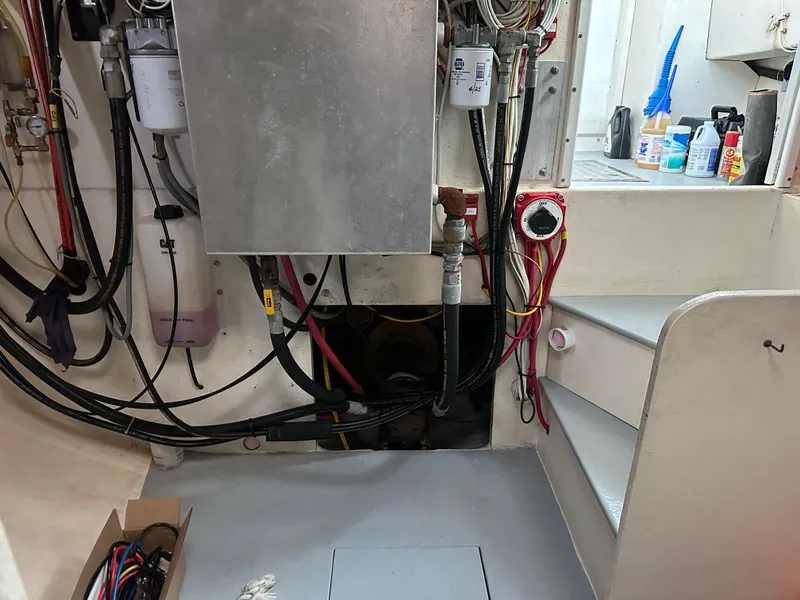 Slide: The Image of Engine room of a 2003 BHM Sport Fish boat with wiring and maintenance supplies. - 28