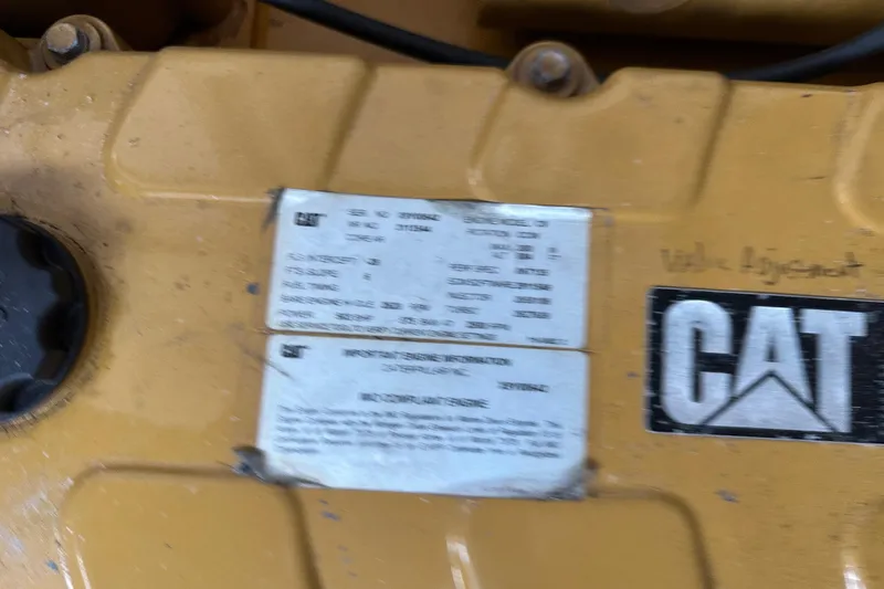 Slide: The Image of Yellow CAT engine with identification labels, part of a 2003 BHM Sport Fish boat. - 35