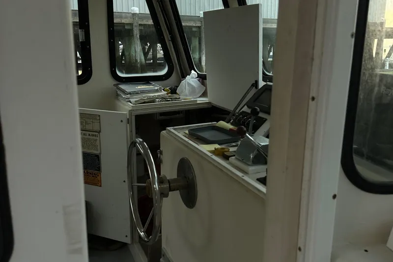 Slide: The Image of Interior of a 2003 BHM Sport Fish boat showing steering wheel and control panel. - 7