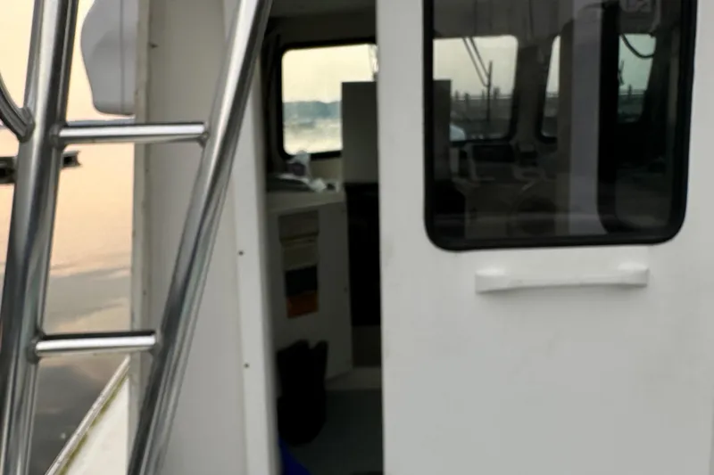 Slide: The Image of 2003 BHM Sport Fish boat cabin with ladder, docked at sunset. - 8