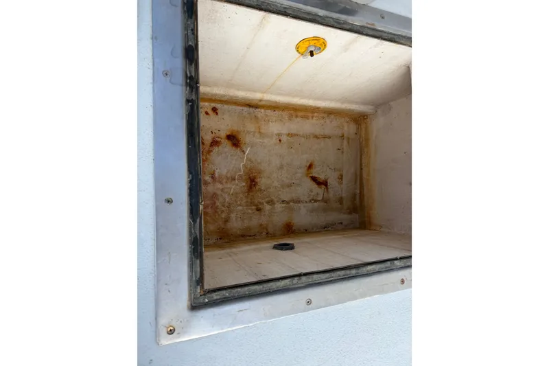 Slide: The Image of Open storage compartment on 2003 BHM Sport Fish boat, showing interior condition. - 25