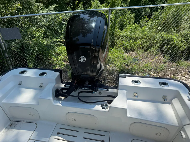 Slide: The Image of 2022 Boston Whaler 170 Montauk boat with outboard motor, surrounded by greenery. - 40