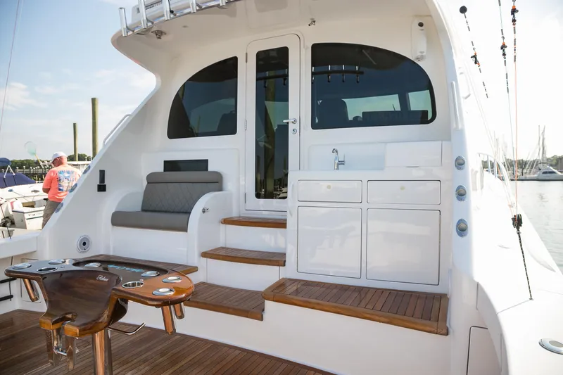 Slide: The Image of 2022 Viking 54 Sport Coupe yacht with outdoor sink and ocean view. - 20