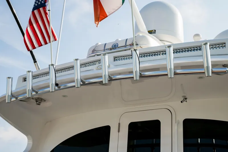 Slide: The Image of 2022 Viking 54 Sport Coupe boat with cushioned seating and wooden deck, overlooking the ocean. - 21