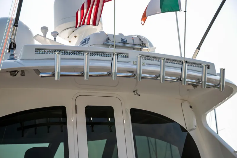 Slide: The Image of 2022 Viking 54 Sport Coupe yacht deck with polished wood table and seating. - 29