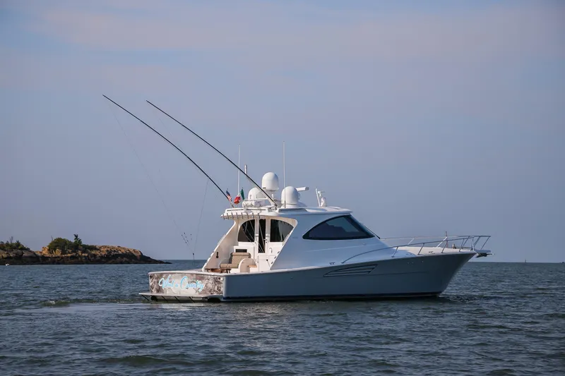 Slide: The Image of 2022 Viking 54 Sport Coupe yacht cruising on calm blue waters. - 3
