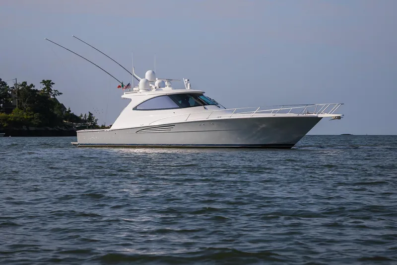 Slide: The Image of 2022 Viking 54 Sport Coupe yacht on calm blue water under clear sky. - 4