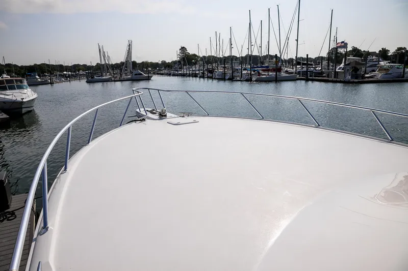 Slide: The Image of Wooden storage cabinet inside 2022 Viking 54 Sport Coupe yacht, featuring multiple shelves and hooks. - 55