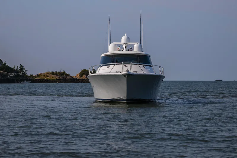 Slide: The Image of 2022 Viking 54 Sport Coupe cruising on open water, creating dynamic wake patterns. - 7