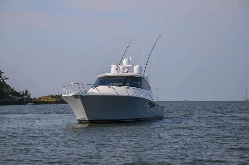 Slide: The Image of 2022 Viking 54 Sport Coupe cruising on open water, creating a dynamic wake. - 8