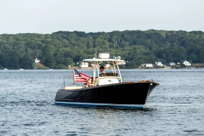 Slide: The Image of 2014 Hinckley T29 CC boat cruising on a lake with American flag. - 10