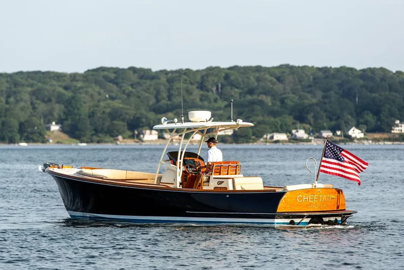 Slide: The Image of 2014 Hinckley T29 CC boat on water, American flag, scenic background. - 21