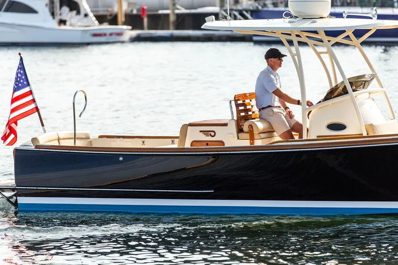 Slide: The Image of 2014 Hinckley T29 CC boat on water, American flag, person steering. - 22